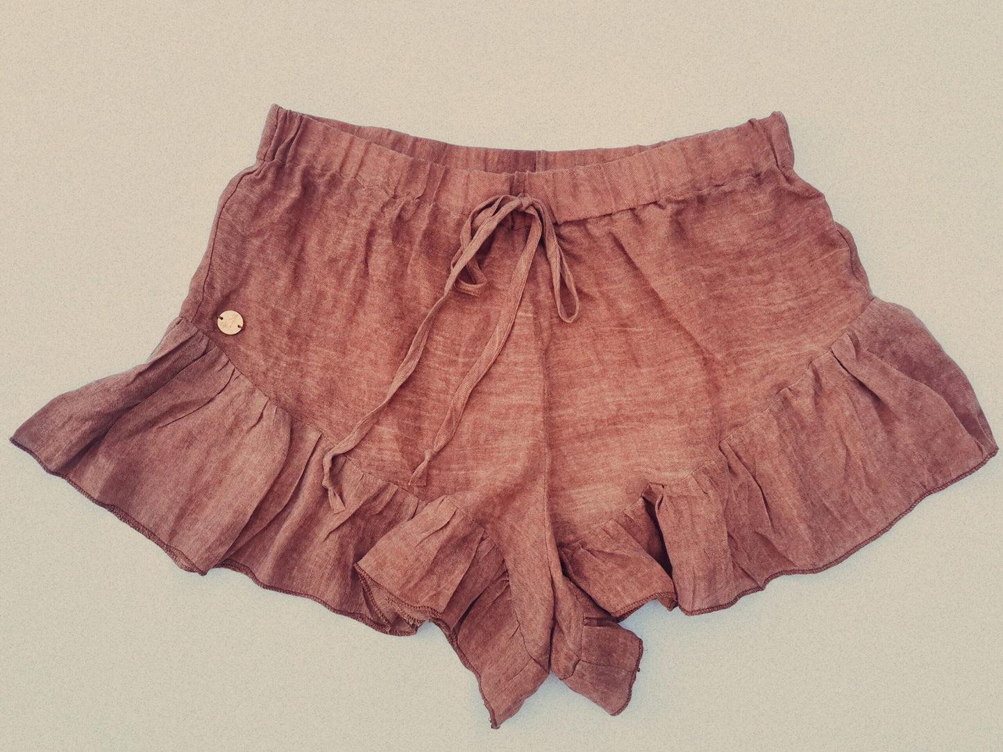 A close up image of luxurious rust coloured linen loungewear shorts designed and manufactured in South Africa