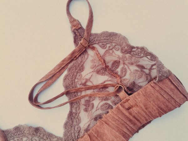 Close up photograph showing the lace detail on a bespoke pink lace bralet designed and manufactured in South Africa.